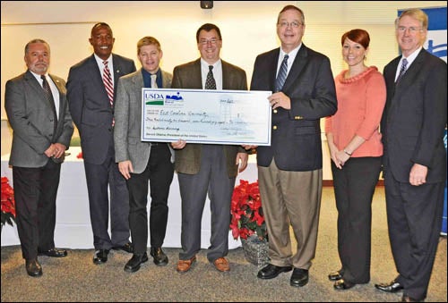 From left, Billy Barker, field representative for Rep. Mike McIntyre; Randall Gore, state director of USDA Rural Development; Phillip Allen, director of informatics operations at the dental school; Dr. Todd Watkins, assistant dean for dental education and informatics at the dental school; Dallas Tonsager, undersecretary for USDA Rural Development; Donnarie Hales, grants coordinator at the school; and Dr. Greg Chadwick, interim dean of the dental school, show off the symbolic check representing the grant of nearly $373,000 ECU received for telemedicine programs. (Contributed photo)