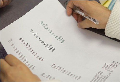 Students in the language academy practice pronouncing words in class, and listen for the difference in similar-sounding words.