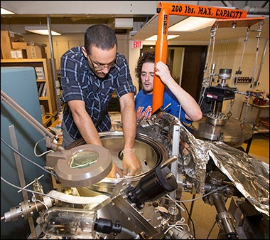 ECU doctoral students Brian Swartz, left, and Eric Maertz prepare a target for an experiment in the ECU Particle Accelerator Laboratory, housed in the Department of Physics.