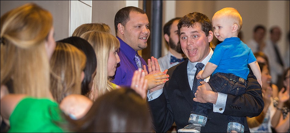 An enthusiastic ECU medical student, Colin Smith, holds an apparently equally enthusiastic Christopher Smith during Match Day at ECU.