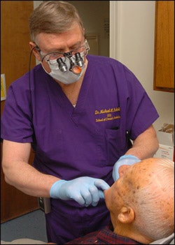 Dr. Michael Scholtz of the ECU School of Dental Medicine checks Willie Green of Rocky Mount during a dental screening at the Feb. 21 wellness day in Rocky Mount.