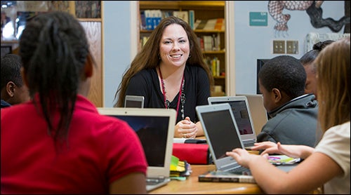 Meredith Hill, an ECU graduate in library science, assists students with computer activities in the library at Creekside Elementary.