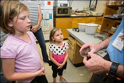 Sara Kimmel, left, and Rachel Kimmel listen as ECU professor Tom Fink discusses the sounds that insects make.