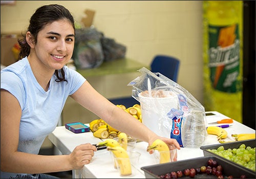 ECU junior Emily Ewing prepares snack cups with healthy treats for children at the Farmville Boys and Girls Club. Approximately 75 snack cups were created.