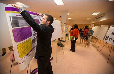 In the category of social sciences, undergraduate Benjamin Wigand prepares his poster presentation, "Gender Differences in the Impact of an Early Warning System and Tutoring in College.