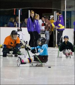 William Hulslander, far left wearing orange, warms up for a game of sled hockey.