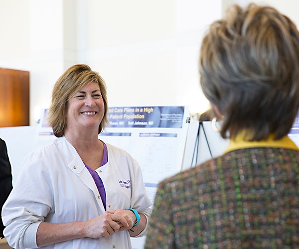 Lorie Sigmon of ECU’s College of Nursing speaks with a symposium attendee at this year’s QI Symposium – part of an American Medical Association-funded program to shape the future of medical education. 