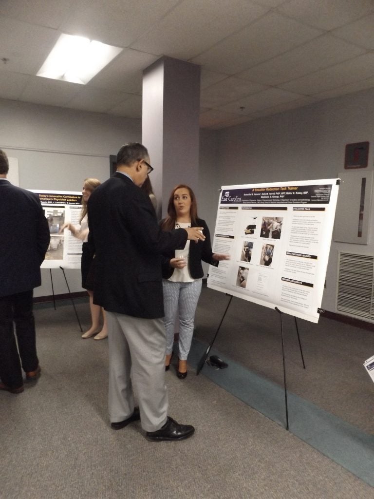 College of Engineering student Samantha Hamann discusses her poster with Brody dean Dr. Paul Cunningham during the university’s second annual Medical Education Day. 