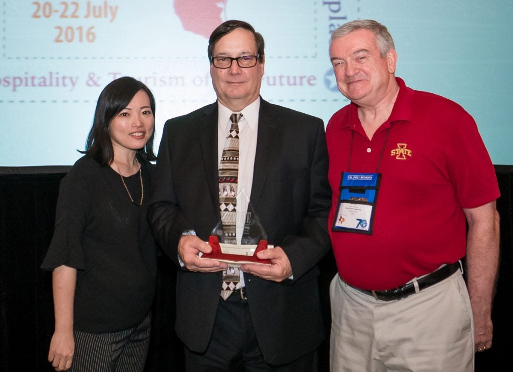 Dr. George Fenich (center) receives the Stevenson W. Fletcher Achievement Award with Dr. SoJung Lee (left) and Dr. Robert Bosselman (right) from Iowa State University.