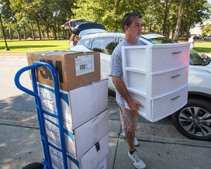 Barry Cook, father of ECU freshman Cara, carries belongings into Jarvis Hall.