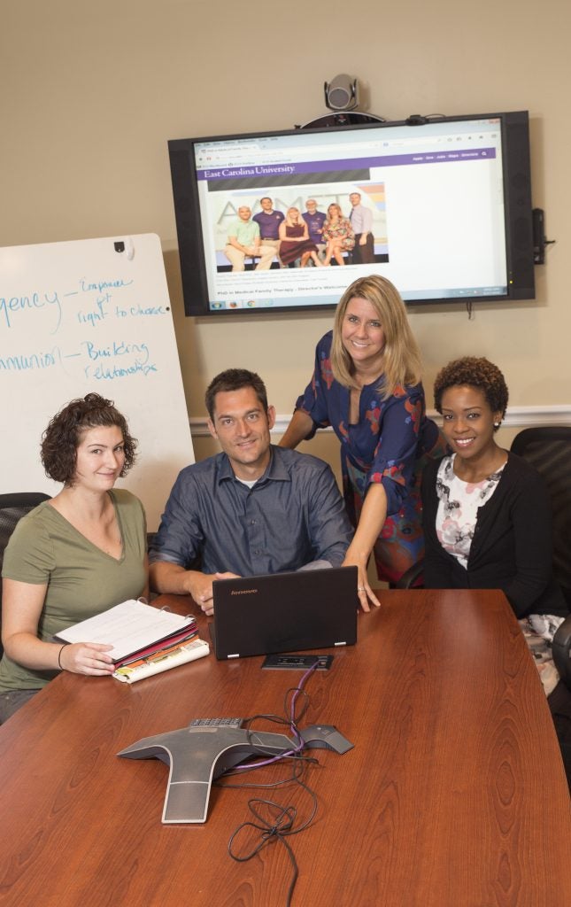 ECU medical family therapy doctoral student Mary Moran meets with Drs. Jake Jensen, Jennifer Hodgson, director and Glenda Mutinda, fellow student.