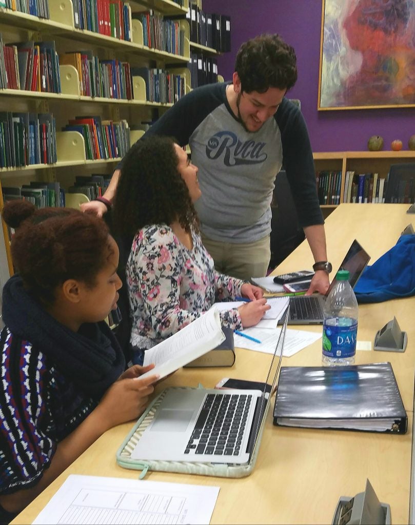 (starting with the closest) Freshmen, TayAndra Allen, Paige Yanik, and Jacob Abolos work together in close proximity to new electrical outlets for easy charging. (Photo by Kelly Rogers Dilda)