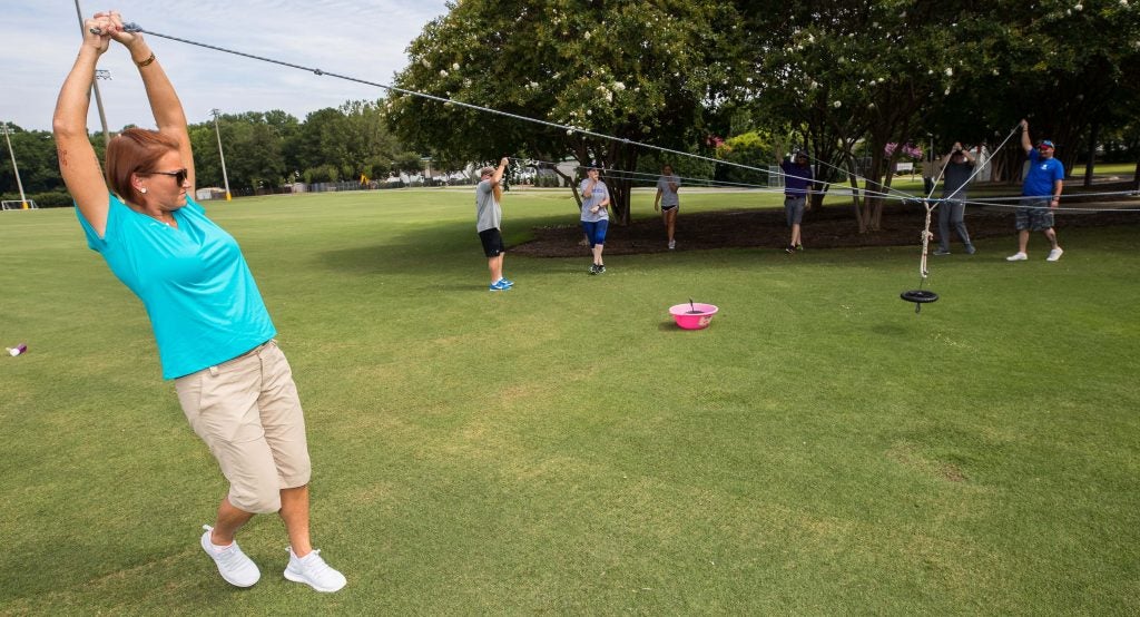 Meranda Baggett lifts a rope high to keep tension on it.