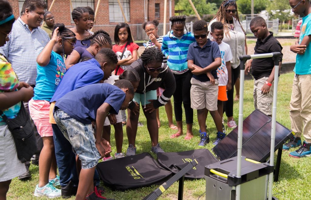 Dr. Ranjeet Agarwala (top left) and students at the Lucille Gorham Intergenerational Center test solar panels and a portable power station. (Photos by Erik Panarusky)