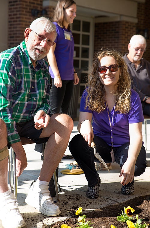 Graduate student Ashley Ritter and participant Ervin Harris plant flowers at the ECU College of Allied Health Sciences. 