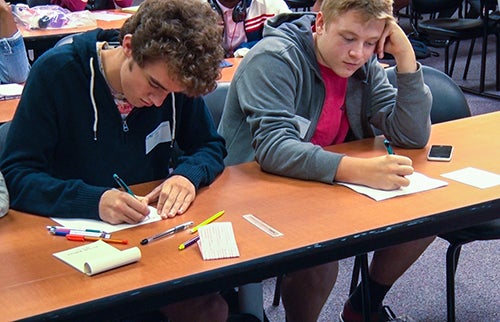 High school students work on drawing presidential cartoons as part of a political cartoon presentation by editorial cartoonist Bob Gorrell.