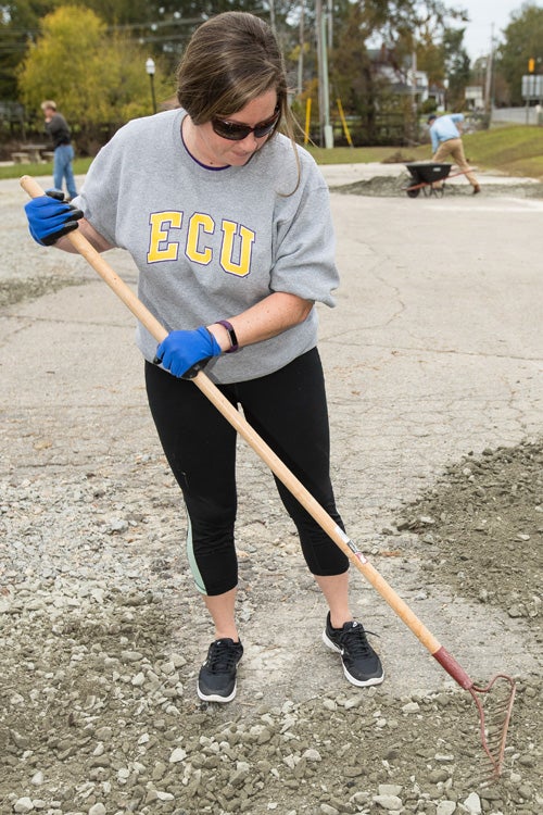 ECU student Jessica Parker level gravel in a parking area at a town park in Windsor on Oct. 31.