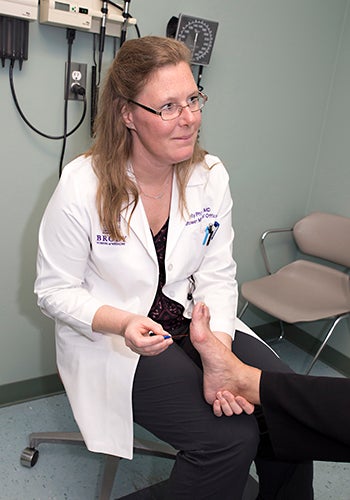 Dr. Kelly Philpot of ECU Physicians examines a patient's foot, an important part of diabetes care.