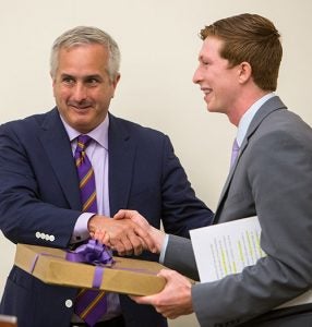 Outgoing SGA President Mark Matulewicz accepts a gift from Board of Trustees chairman Steve Jones.