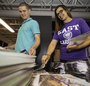 Mike Ryan (left) and Brittney DeWitte compile information packets to help introduce new students to ECU during orientation.