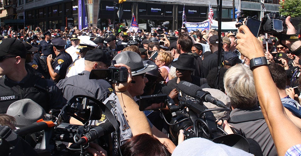 A small group of protesters in Cleveland is ringed by police, who are surrounded by multiple rings of press.