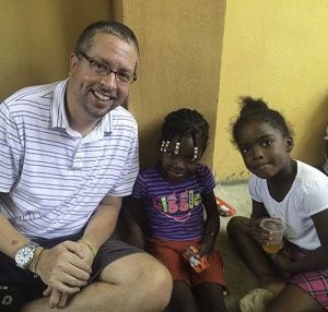 Andrew Kievit ’96 visits with children during a recent trip to the Dominican Republic. (Contributed photo)