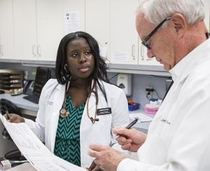 Brody student Jasmine Bryant assists Dr. Robert Shaw at a volunteer clinic in December 2015.