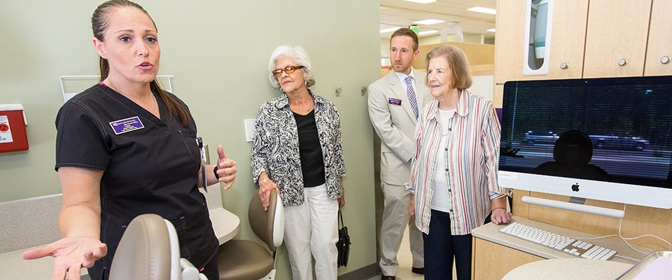 Dental hygienist Roberta Bunnell leads a tour before the ceremony begins.