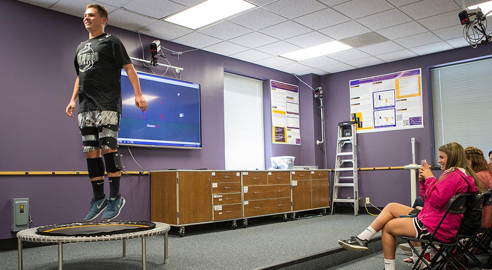 Payton Piscorik, a student at the Oakwood School, bounces on a trampoline wearing motion capture gear during a National Biomechanics Day demonstration in the Ward Sports Medicine building at ECU.