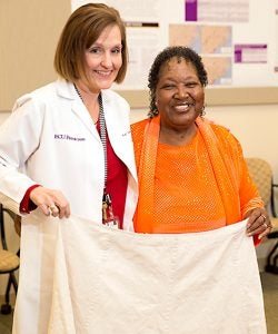 Kay Craven and Carolyn Daniels hold a skirt Daniels wore before shedding 57 pounds.