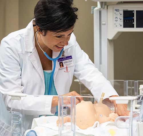 Graduate student Cassandra Elder, RN, practices neonatal assessment.