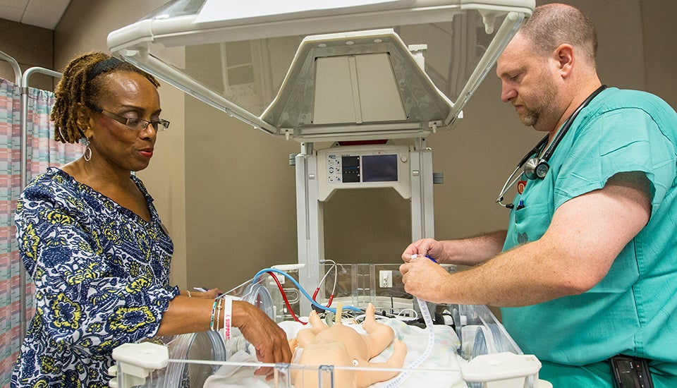 Dr. Pamela Reis, assistant professor in the College of Nursing, and John Bailey work at the neonatal assessment station.