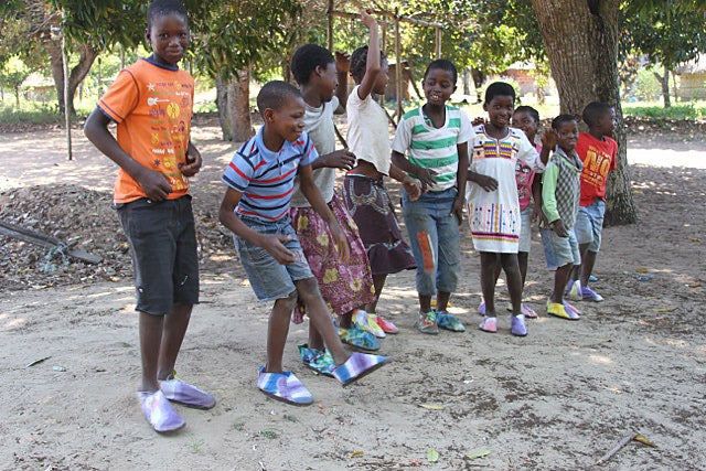 Children show off their new, hand-made shoes in a village in Mozambique.