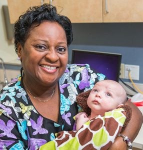 ECU Physicians’ Nurse of the Year Linda Richardson holds patient Sylas Lane in the pediatric clinic at the East Carolina Heart Institute.
