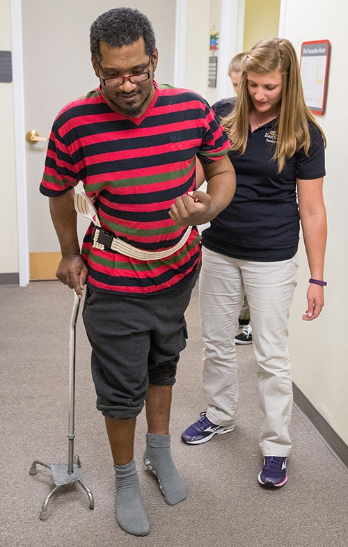 Physical therapy student Laura Needham works with patient Ronald Powell.