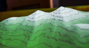 A projector and an Xbox Kinect camera create a closed loop that displays contour lines, elevations and water flows on the sandbox landscape.