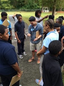 ECU intern Jared Ingle (center, plaid shirt) mentors eighth-grade students at C.M. Eppes Middle School in plant biology and ethno-botany. (Photo provided by Karen Quick, C.M. Eppes Middle School)