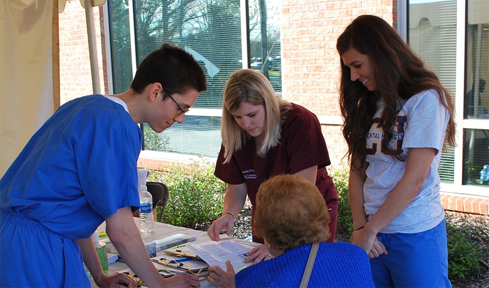 ECU dental students David Morrison, Ali Denny and Madison Smith were part of the team that registered individuals to become patients at ECU Smiles.