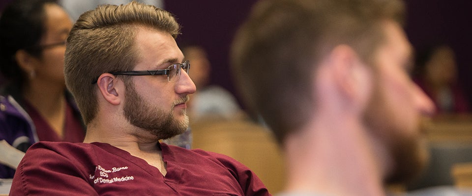 Dillon Burns, a second-year dental student, listens to Dr. Summerhays during her visit to ECU.