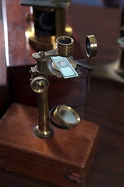 This 1840 solid brass Gould- or Ellis-type microscope has its own wooden storage case and is said to be similar to one used by a young Charles Darwin in his five-year voyage on the Beagle.