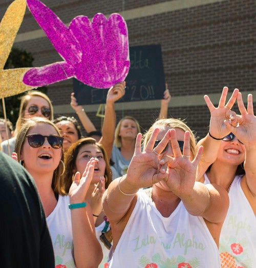 Zeta Tau Alpha greets people walking into Minges for convocation.