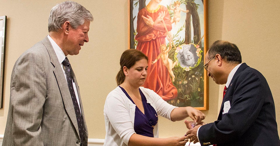 Atul Goel receives his tassel from Nicole Jablonski and Chancellor Steve Ballard. (Photo by Josh Vaughan)