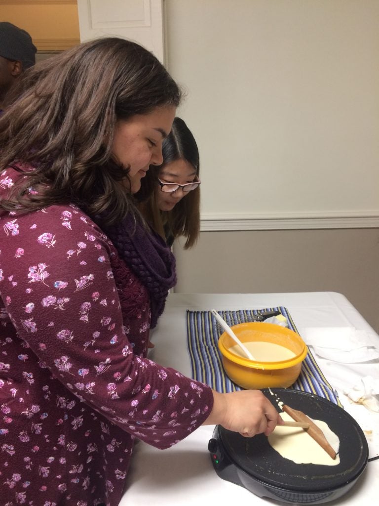 Global Living-Learning Community students Genesis Henderson and Maia Slonaker make their own crêpes at the interactive academic and cultural event.