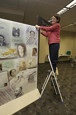 Dr. Ruth Moskop, curator of history collections, arranges part of the "Suitcases" exhibit at Laupus Library. Photo by Cliff Hollis