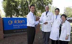 From left, Hal Garland, executive director of Golden Living Center, presents a check for $110,801 to fund geriatric teaching programs to Dr. Kenneth Steinweg, interim chairman of family medicine; Dr. Tae Joon Lee, medical director at Golden Living Center;