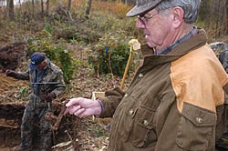 R. Ward Sutton holds a piece of hardware from the casket of a child at the site of a forgotten graveyard near the planned ECU School of Dentistry. Photo by Doug Boyd