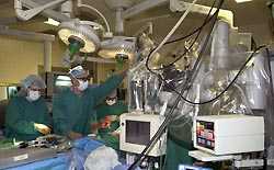 Cardiothoracic surgeons at University Health Systems of Easten Carolina in Greenville prepare the da Vinci surgical robot for a mitral valve procedure. Photo by Cliff Hollis.