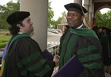 New physicians Ken Dunham, left, and Anthony Hayes congratulate each other after receiving their medical degrees at the Brody School of Medicine convocation May 9. Photo by Cliff Hollis