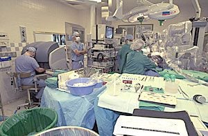 Dr. Randolph Chitwood, far left, performs surgery from the da Vinci Surgical System console during the 100th mitral valve surgery using the da Vinci Surgical System at Pitt County Memorial Hospital. For more photos, click here. Photo by Cliff Hollis