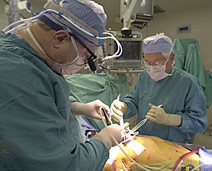 Dr. Randolph Chitwood, left, and physician assistant Larry King prepare a patient for mitral valve surgery with the da Vinci Surgical System. Photo by Cliff Hollis